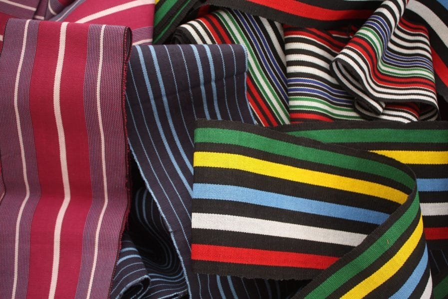 Detail of hand-woven aso oke fabric showing the weave structure and metallic thread