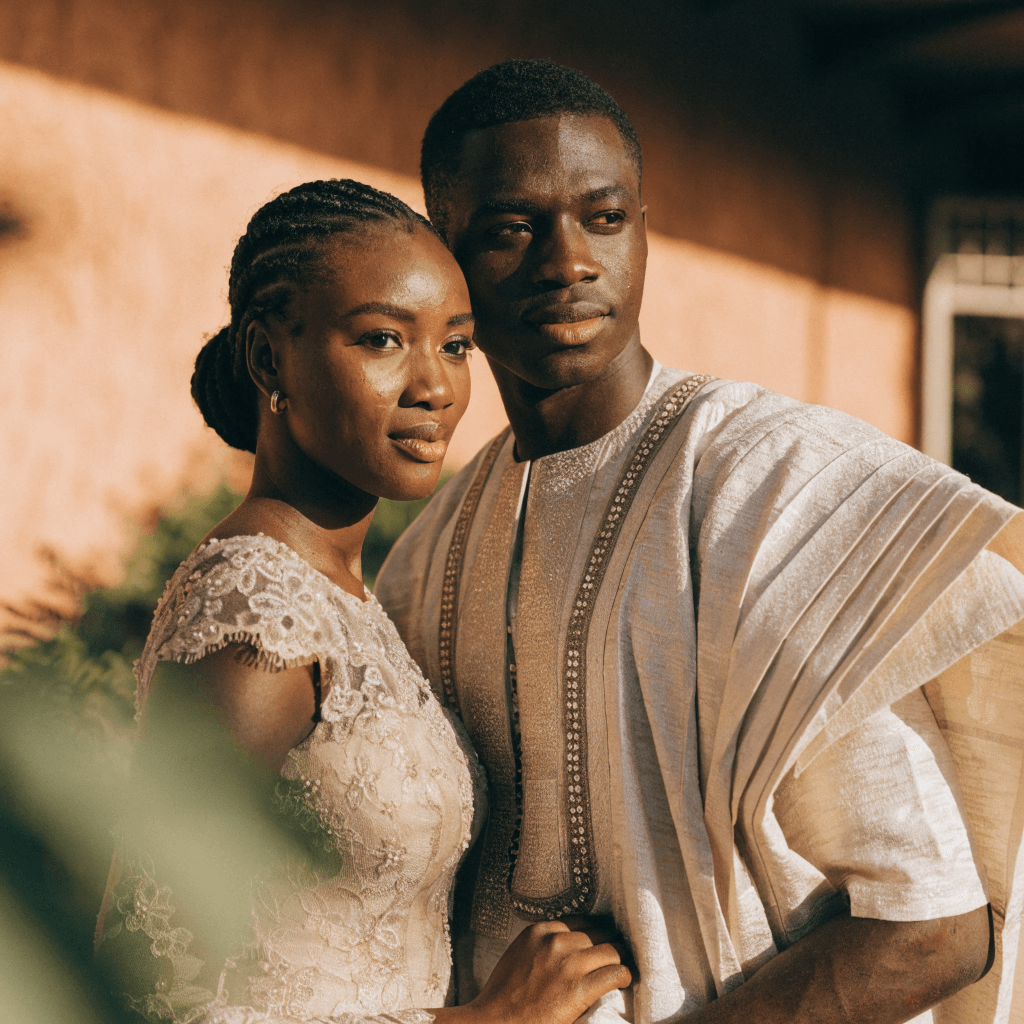 Nigerian bride and groom in coordinated pre-wedding shoot looks against a warm neutral backdrop