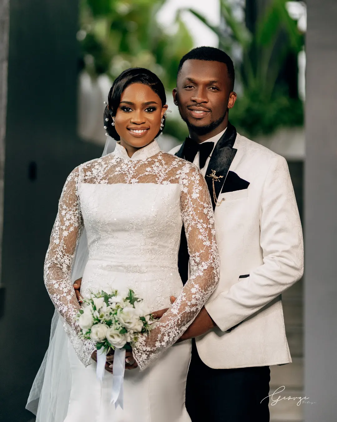 Bride in Bojamiley high neck lace wedding dress with groom in white tuxedo