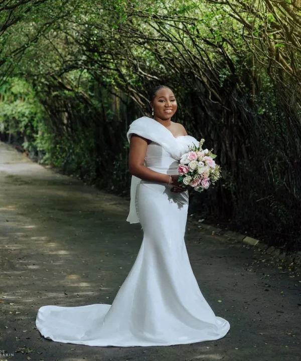An image of a simple white wedding dress off shoulder wedding dress