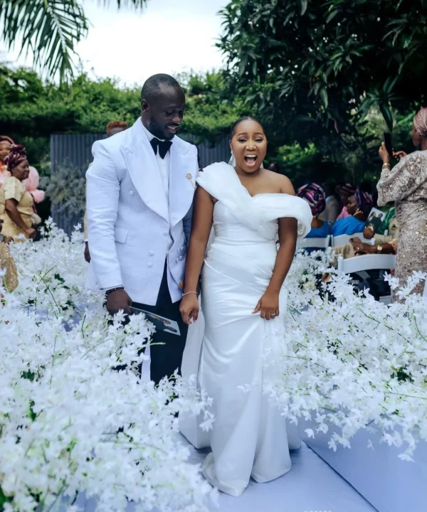 An image of a simple white wedding dress off shoulder wedding dress